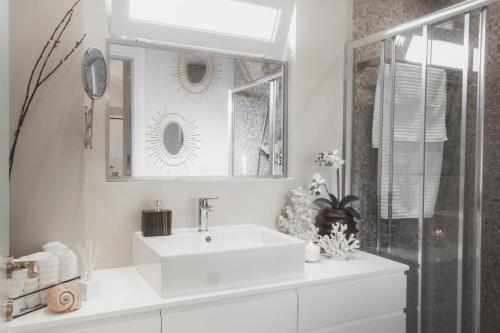 雅典Sea view super romantic apartment的白色的浴室设有水槽和镜子