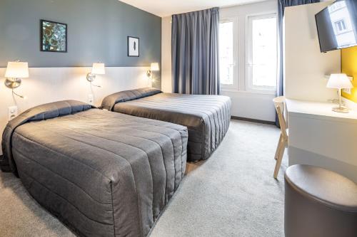 卢尔德米拉索尔酒店的酒店客房配有两张床和一张书桌