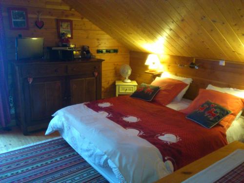莱托利Chalet Gérardmer situé a LE THOLY的一间卧室配有一张带红色毯子的大床