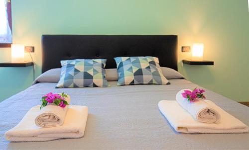 马瑞纳迪卡拉拉B&B Villa Apuana的一间卧室配有带毛巾和鲜花的床
