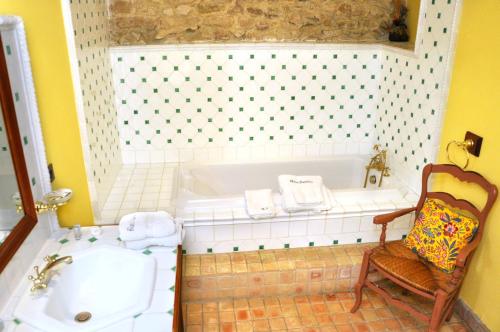 纳博讷Chambres d'hôtes Château de Jonquières的带浴缸、椅子和水槽的浴室