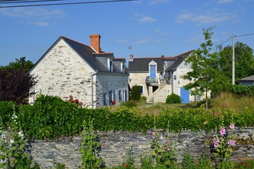 La Daguenière德格鲁瓦度假屋的白色的房子,有石墙和鲜花