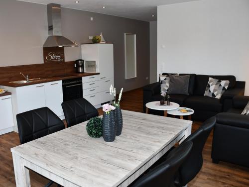 锡默拉特Zum Anker的厨房以及带桌椅的起居室。