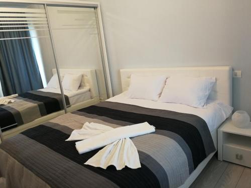 马马亚Inima Mamaia LuxyMar 2 Apartment的一间卧室配有一张带两条白色毛巾的床