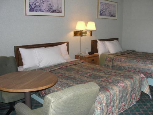 阿尔科Budget Inn的酒店客房,设有两张床和一张桌子及椅子