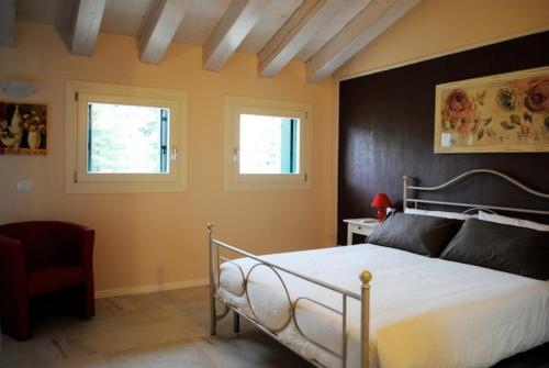 维罗纳自由镇Bed And Breakfast Castello的一间卧室设有一张床和两个窗户。