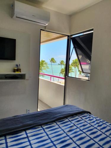 马塞约Vista pro mar的一间卧室配有一张床,享有海滩美景