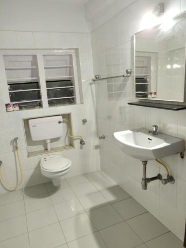 孟买YWCA International Centre的白色的浴室设有卫生间和水槽。