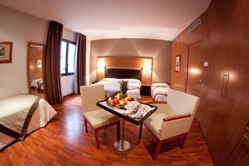 巴涅尔-德吕雄阿尔蒂酒店的酒店客房,配有床和一张带水果的桌子