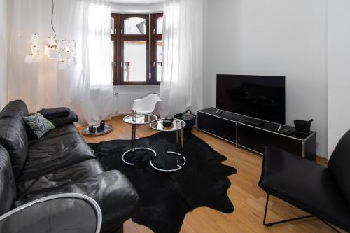 特里尔Casa Augusta - Urban Living的客厅配有真皮沙发和电视