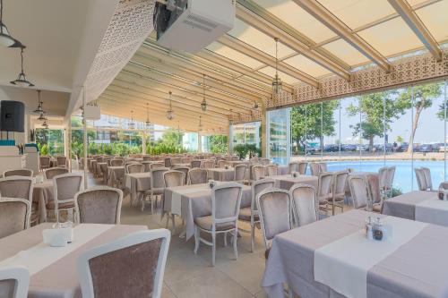 马马亚苏利纳国际酒店的宴会厅配有白色的桌椅