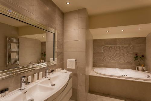纽里运河苑酒店的一间带浴缸和大镜子的浴室