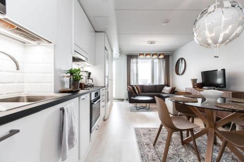 奥卢Citykoti Oulu的厨房以及带桌子和沙发的客厅。