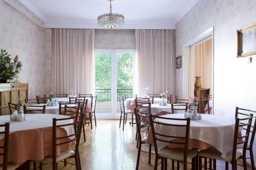 科扎尼阿尼西斯酒店的一间带桌椅的用餐室和大窗户