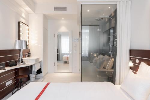 汉堡Ruby Lotti Hotel Hamburg的一间卧室配有一张床,浴室设有淋浴。