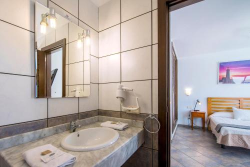 普拉亚布兰卡波多鲁比康别墅酒店的一间带水槽的浴室和一张位于客房内的床