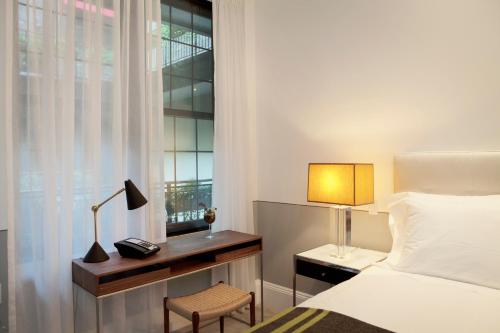 纽约布鲁姆酒店的一间卧室配有一张床、一张书桌和一个窗户。