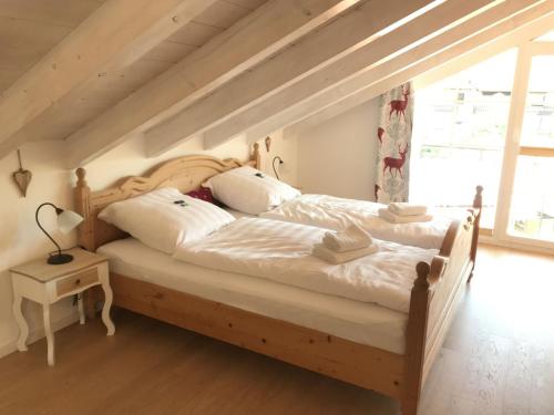 格拉绍Haus Vincent的一间卧室配有一张带白色床单和枕头的木制床。