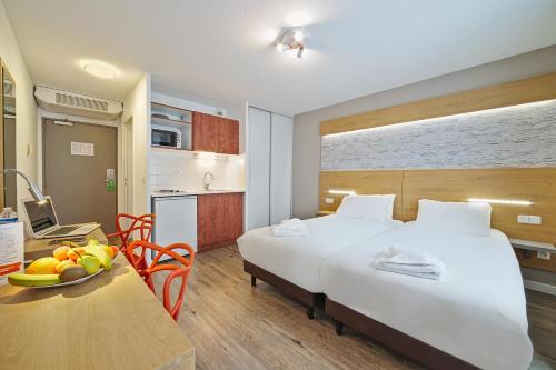 里昂渣油里昂酒店的酒店客房设有一张床和一张带果盘的桌子。