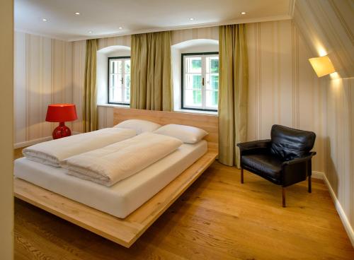 塔尔高Waldach Villa的一间卧室配有一张大床和一张黑椅