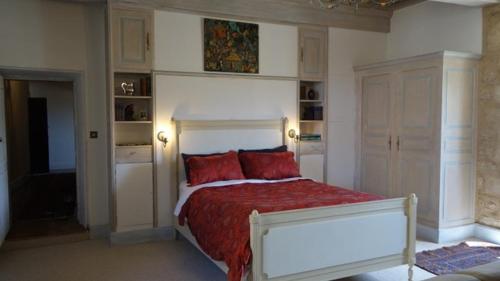 BalsacChateau de Balsac的一间卧室配有一张带红色枕头的大床