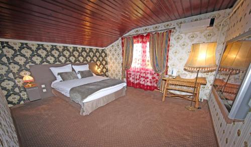 DaiaPensiunea Lokanta的一间卧室配有一张床、一张桌子和一个窗户。