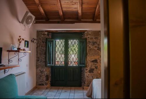 卡拉塔比亚诺Antico Borgo Etneo Agriturismo的窗户房间里一扇绿门