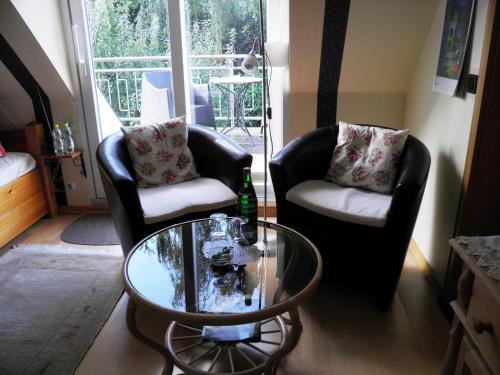腓特烈吉曼旅馆的客厅配有两把椅子和一张玻璃桌