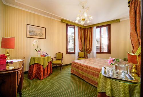 威尼斯凯特酒店的酒店客房带一张床、一张桌子和椅子
