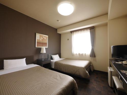 山梨市路线居山梨酒店的酒店客房设有两张床和窗户。