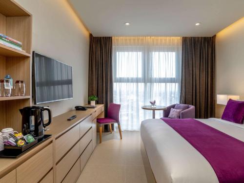 海防海丰美居酒店的一间酒店客房,配有一张床和一台电视