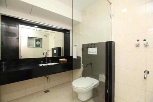 KelambākkamHotel Southern Residency的一间带卫生间、水槽和镜子的浴室