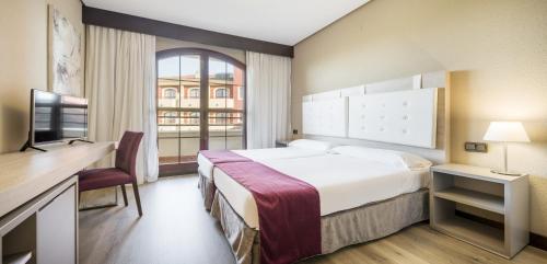 巴达霍斯巴达霍斯依鲁尼恩高尔夫酒店的一间设有大床和窗户的酒店客房