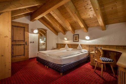 科尔福索Residence Vila的一间带一张大床的卧室,位于一个拥有木制天花板的房间