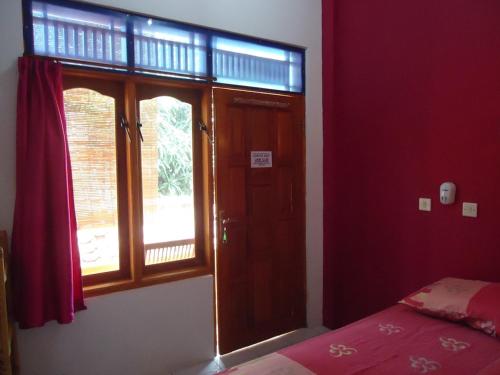 庞岸达兰Kancil homestay的卧室设有红色的墙壁、一张床和窗户