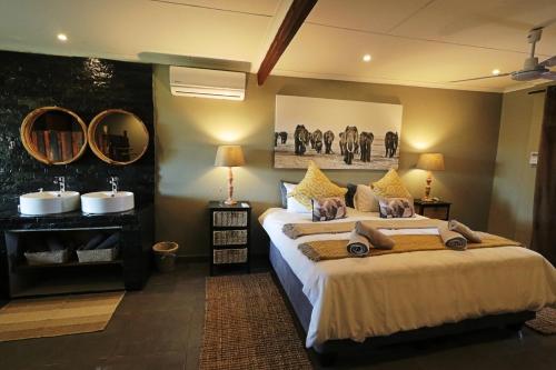 Grietjie Game ReserveNgalali Retreat的一间卧室配有一张大床和两面镜子