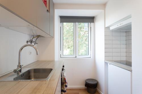 里斯本FLH Lx Factory Modern Flat的厨房设有水槽和窗户。