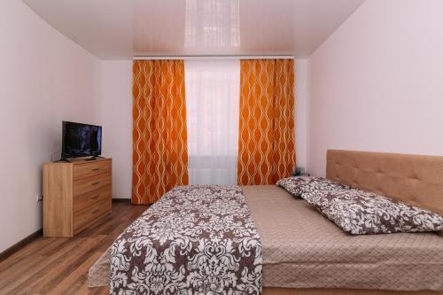 苏梅Apart-hotel on Kondrateva street New Building的一间卧室配有一张床、一台电视和一个窗口