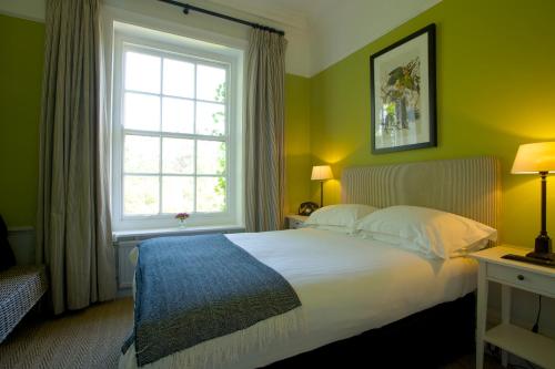 Sway斯维庄园餐厅花园酒店的一间卧室设有一张大床和一个窗户。