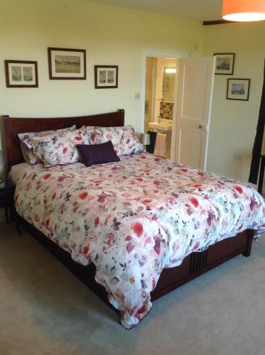 IdenBaron's Grange的一间卧室配有一张带花卉床罩的大床