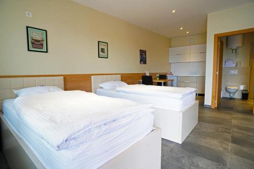 维也纳新城Nava Motel & Storage的带浴室的客房内设有两张单人床。