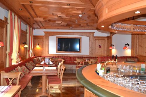 玛利亚采尔圣灵酒店的一间带酒吧的餐厅以及墙上的电视