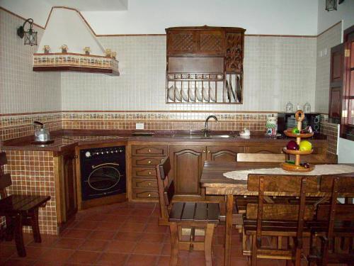 弗龙特拉Casa rural Antonio García的厨房配有木制橱柜和炉灶烤箱。