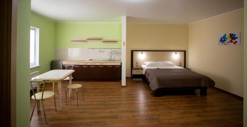 乌曼岛Hotel Complex Olimp的一间卧室配有一张床铺和一张桌子,还设有一间厨房
