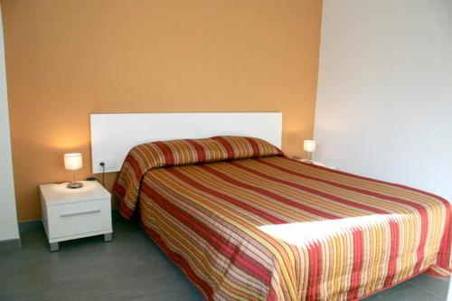 Sant Privat de Bas卡梅莉塔酒店的一间卧室配有一张床和一个带两盏灯的床头柜。