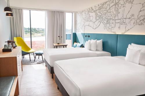 森讷堡Steigenberger Alsik – Hotel & Spa的酒店客房设有两张床,墙上挂有地图。