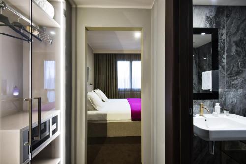 蒙特格罗托泰梅Terme di Relilax Boutique Hotel & Spa的浴室设有床、水槽和镜子