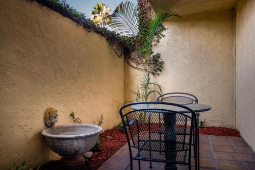 安纳海姆胡椒树精品厨房一室公寓 - 阿纳海姆 的鸟浴,围墙旁,有两把椅子