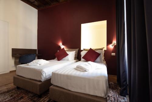 罗马BEIGE ET BLE' GuestHouse的酒店客房 - 带两张带红色枕头的床