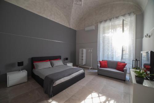 卡塔尼亚Loft Ramondetta 30tre的一间卧室配有一张床、一张沙发和一个窗口